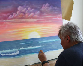 Sylvia am Airbrushbild, Motiv: Sonnenuntergang am Meeresstrand